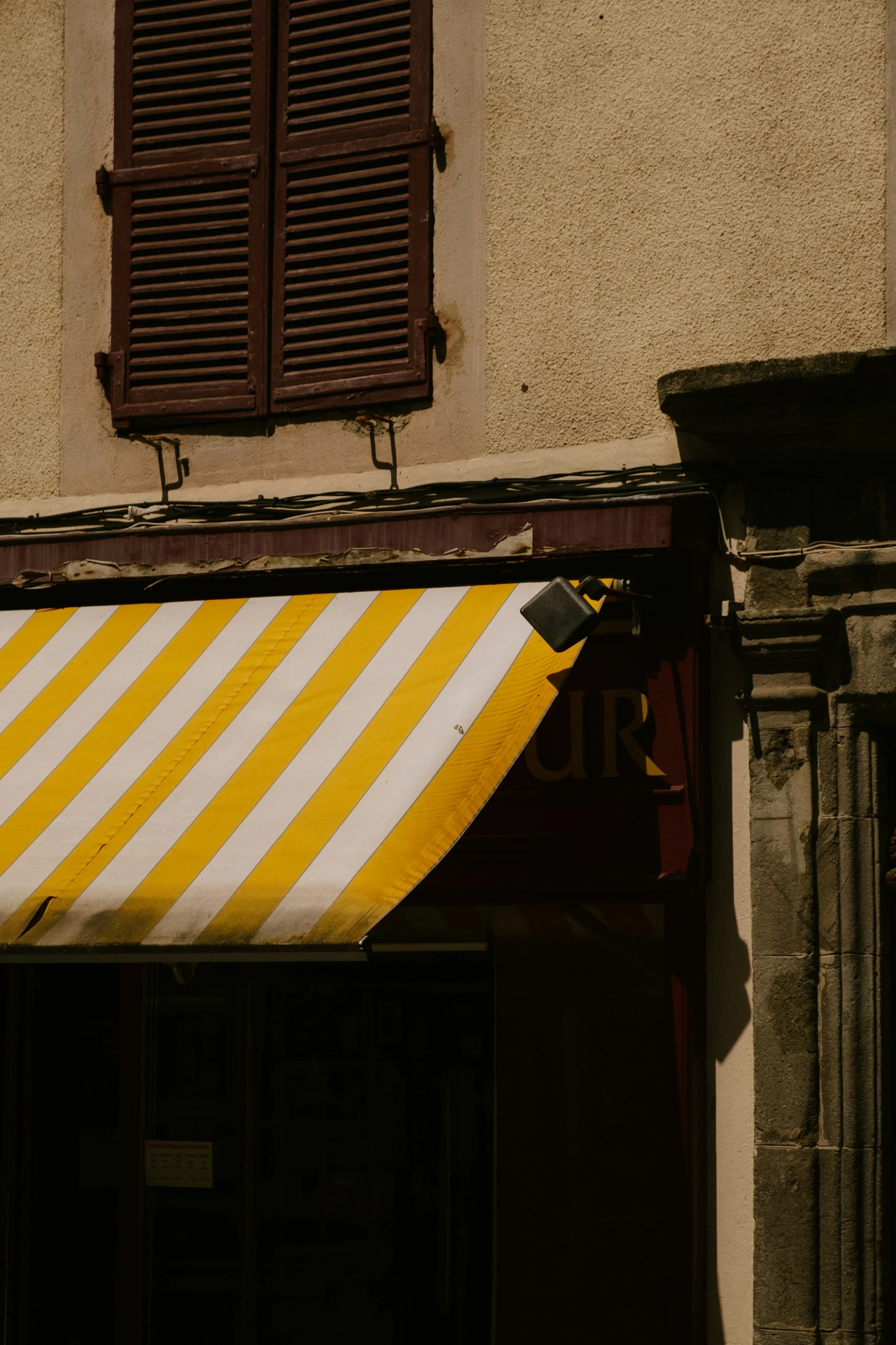 the side of an old building has yellow and white stripes