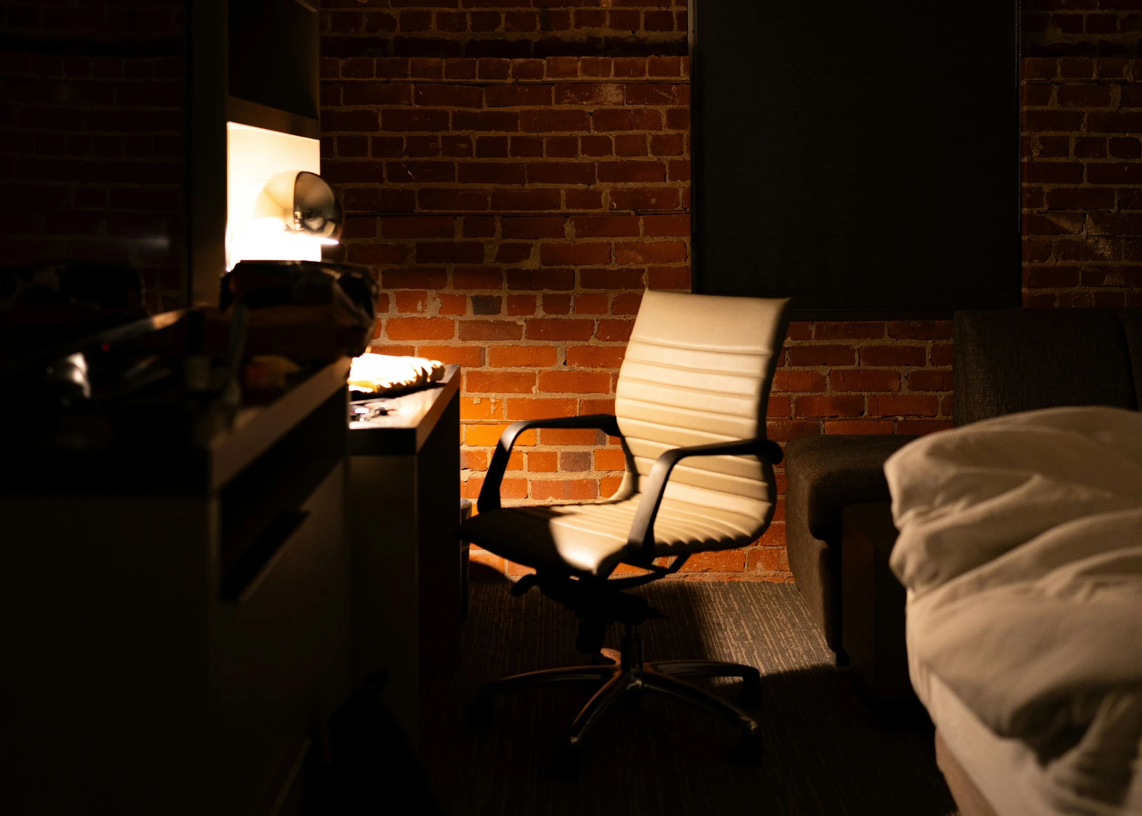 an empty chair in front of a brick wall