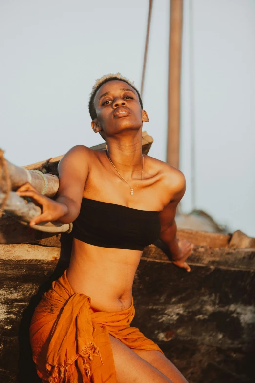 a woman wearing an orange skirt next to a boat