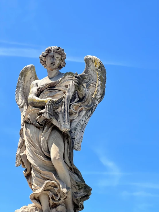 an angel statue holding a sword and a piece of paper