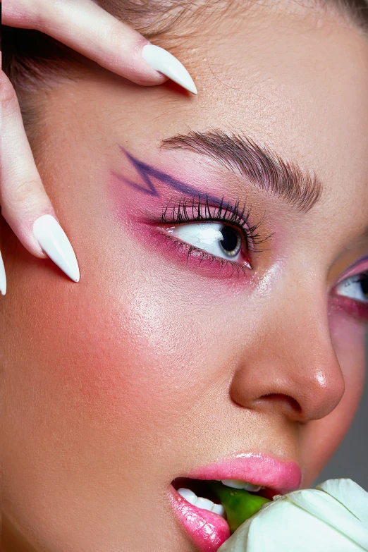 an eye - popping closeup image of a model with pink makeup and stil pointed lashes