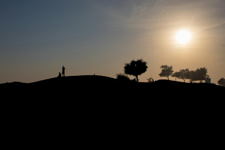 the sun shining down on two people in silhouette