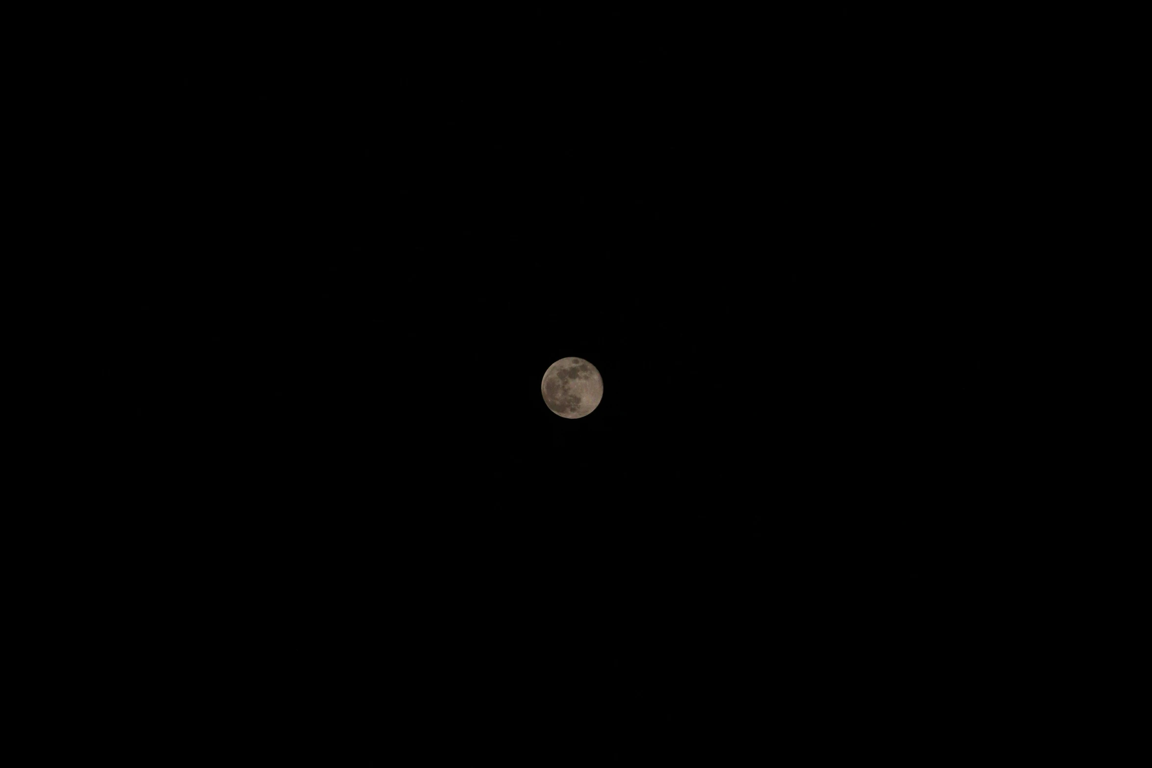 a view of a distant moon seen from the dark