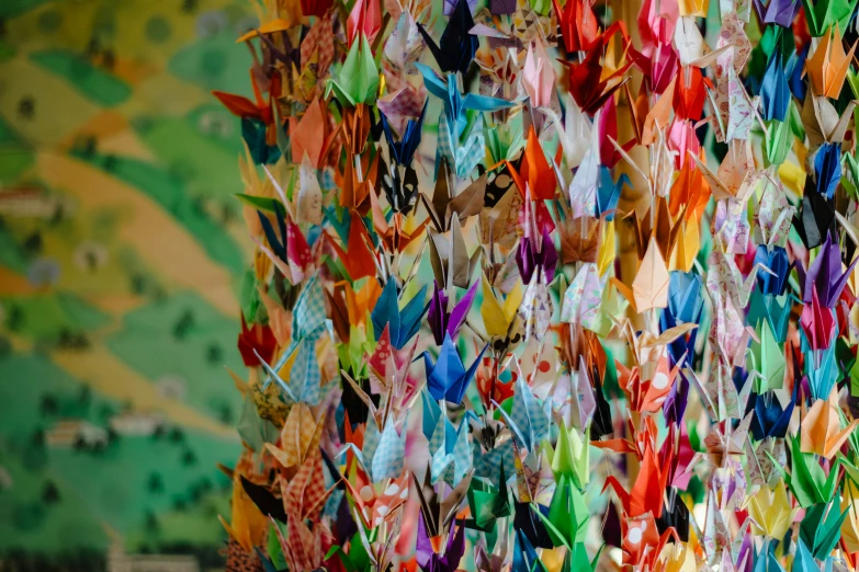 many multicolored paper cranes hanging from the ceiling