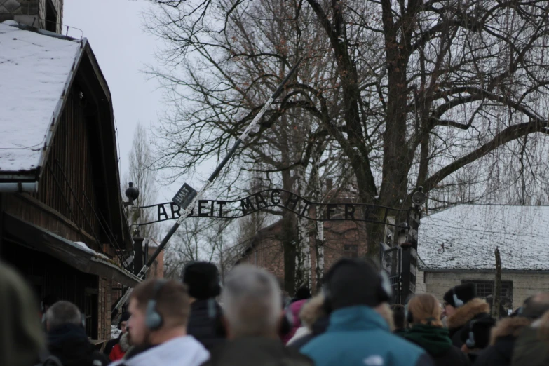 the crowd is standing outside for a street sign