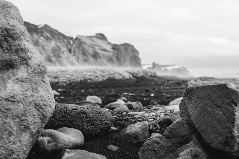 black and white image of rocks at the sea shore