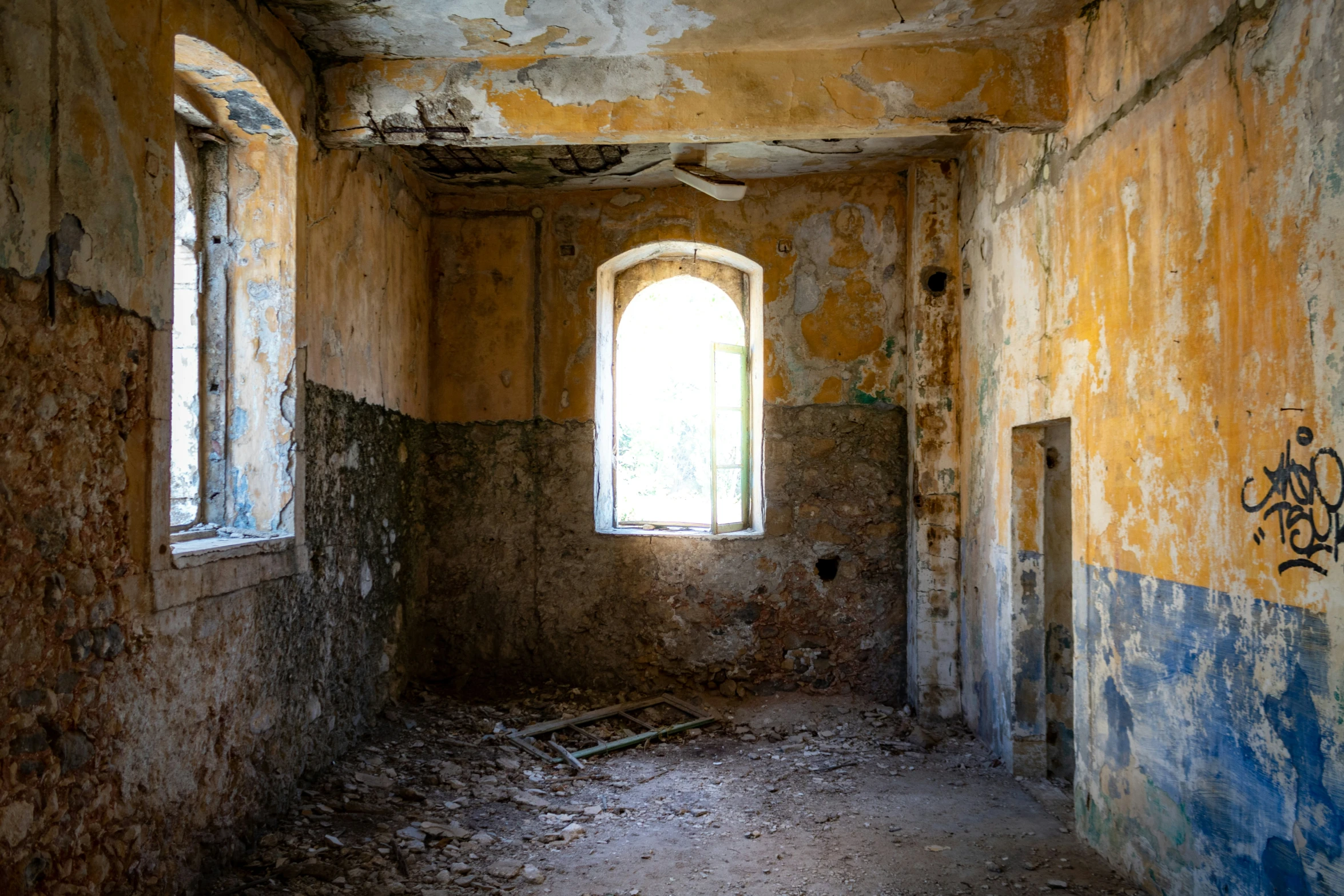 an old room with graffiti and a windows