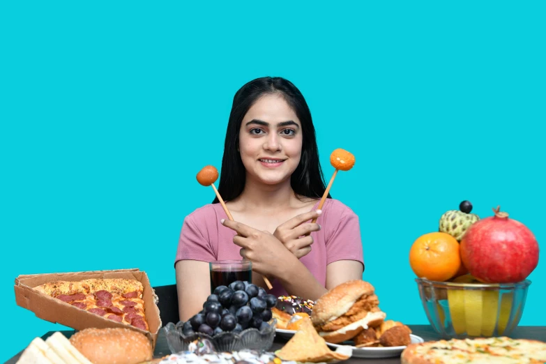 a woman sitting at a table with various food