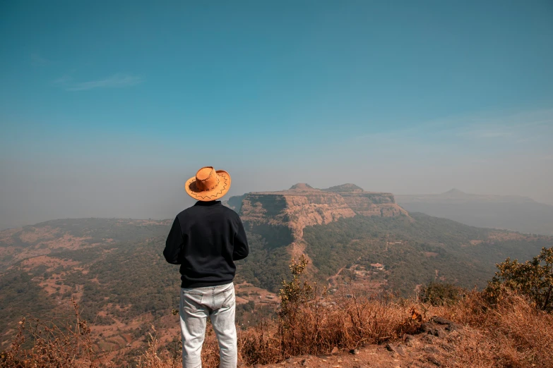 a man stands with his arms outstretched on a mountain