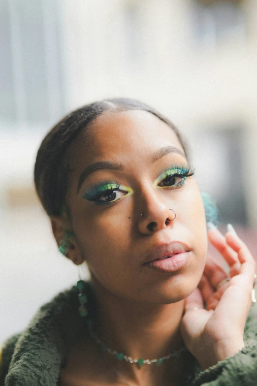 a woman with green makeup and a coat