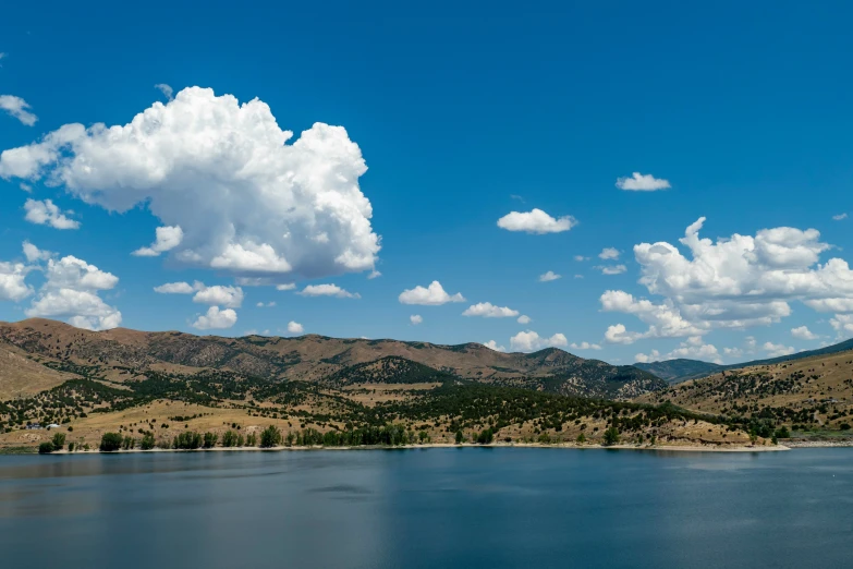 there is a small body of water with a very large cloud in the sky