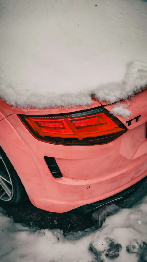 there is a pink car covered in snow