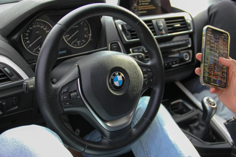 a woman is holding up a smart phone in the car