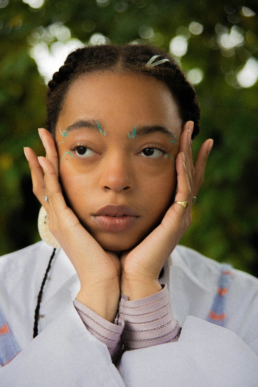 a woman with her hands on her face, looking away from the camera