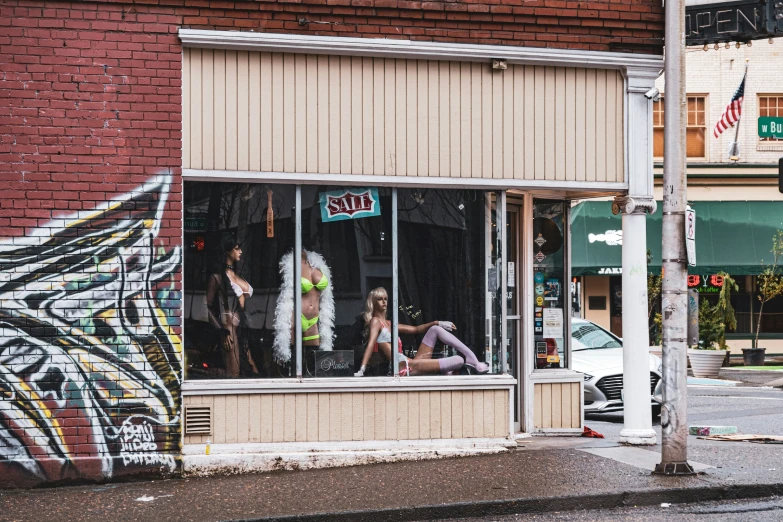 two women standing in a store window looking out