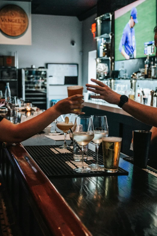 two people sit at a bar making wine