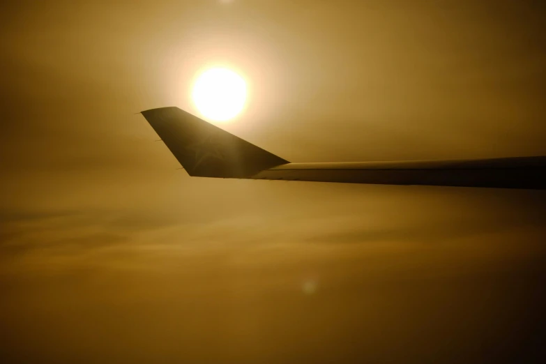 a wing of an airplane as the sun is rising