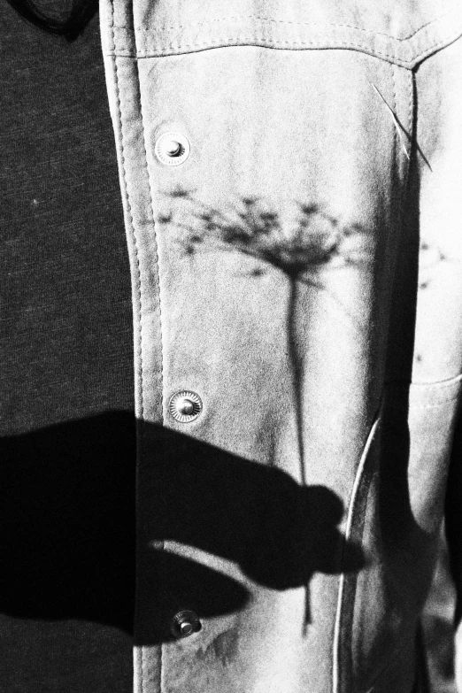 a black and white image of a person's hand touching the ons on a jacket