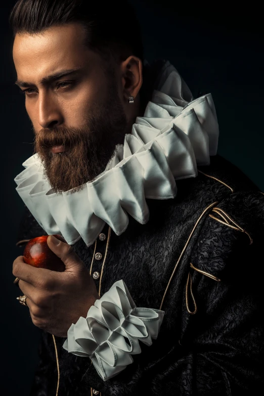 a man with a hairdo and beard holding an apple