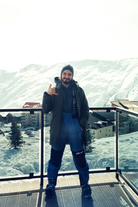 man on deck with his skis giving thumbs up