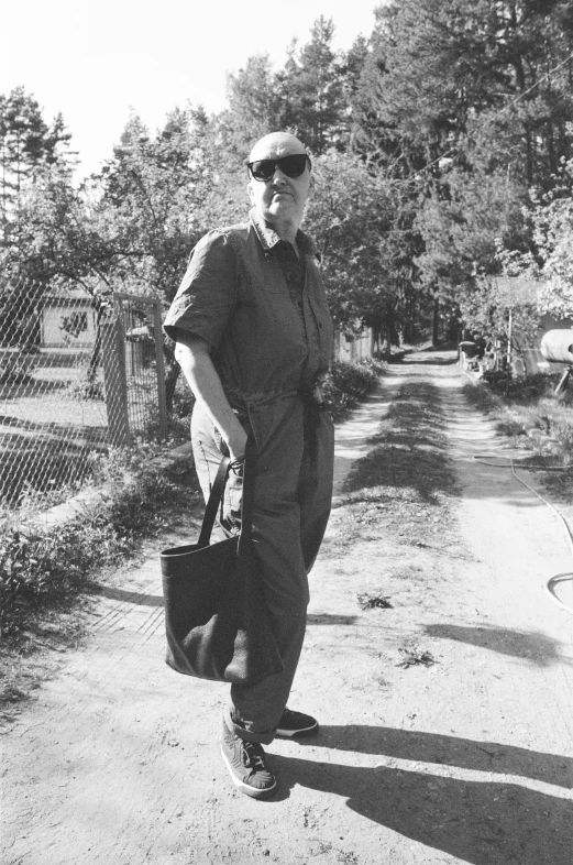 a man standing on a street holding a bag