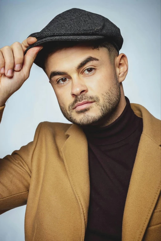 a man wearing a suit and hat leaning against a wall