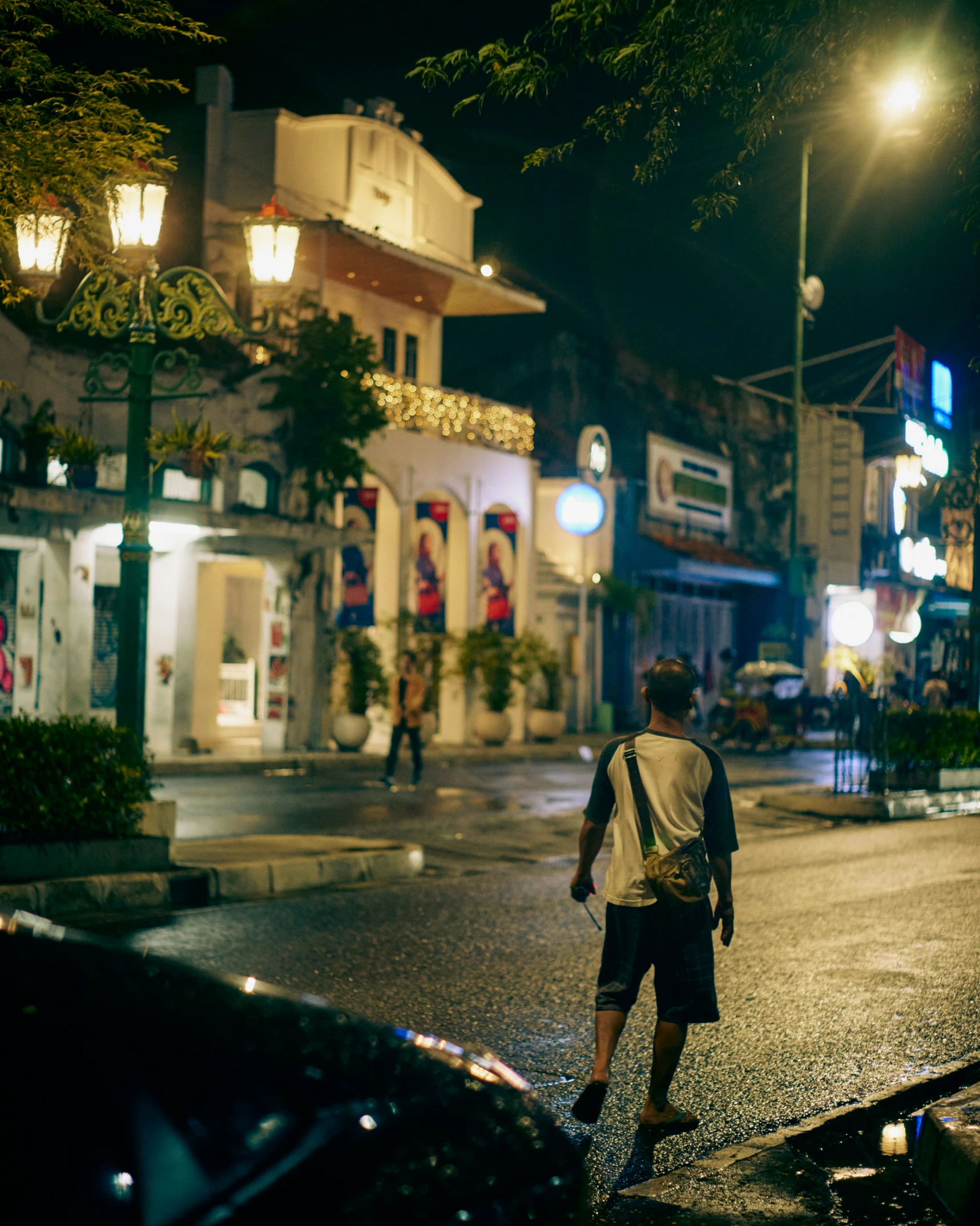 a guy walking across the street with some backpacks