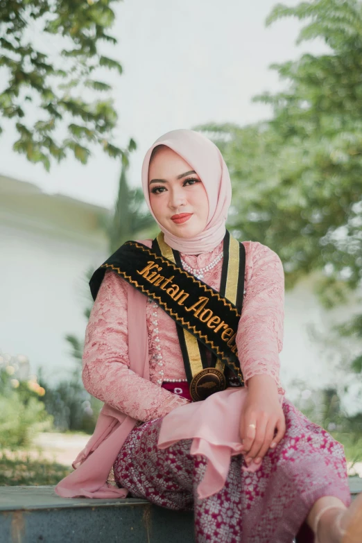 a woman sitting down with a sash around her neck