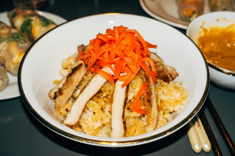 the rice has chicken, carrots and meat in it