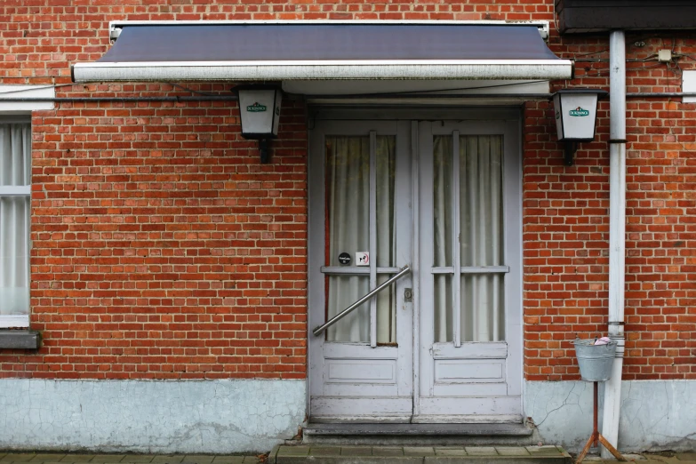 a building with two white doors next to a fire hydrant