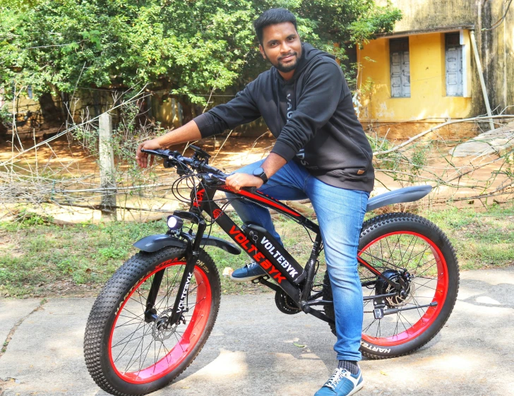 a man is sitting on a bicycle and smiling