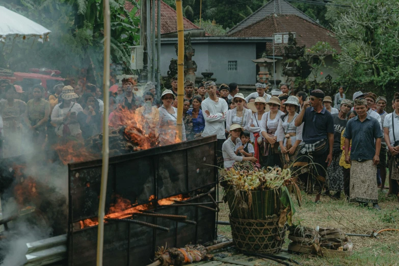 many people standing next to fire, some in white shirts