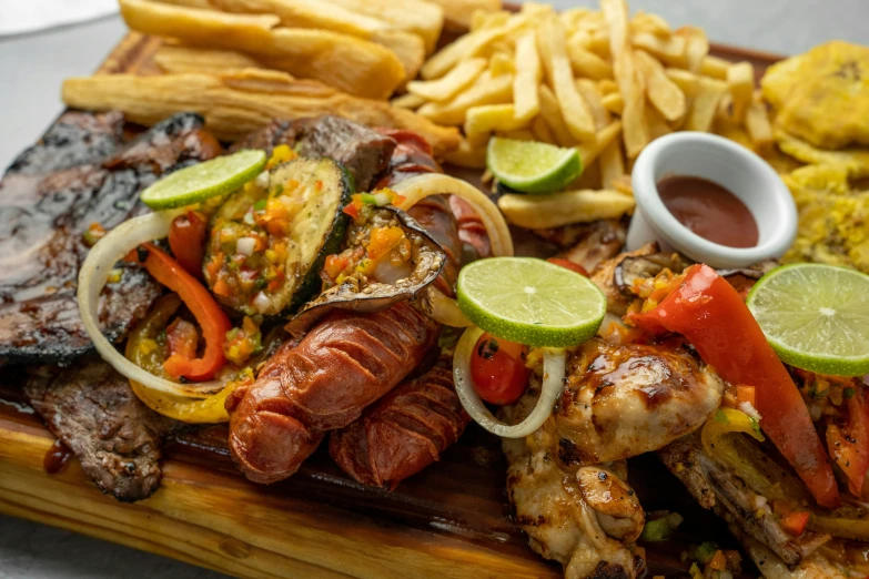 a grilled meat, fries and vegetables on a wood serving board