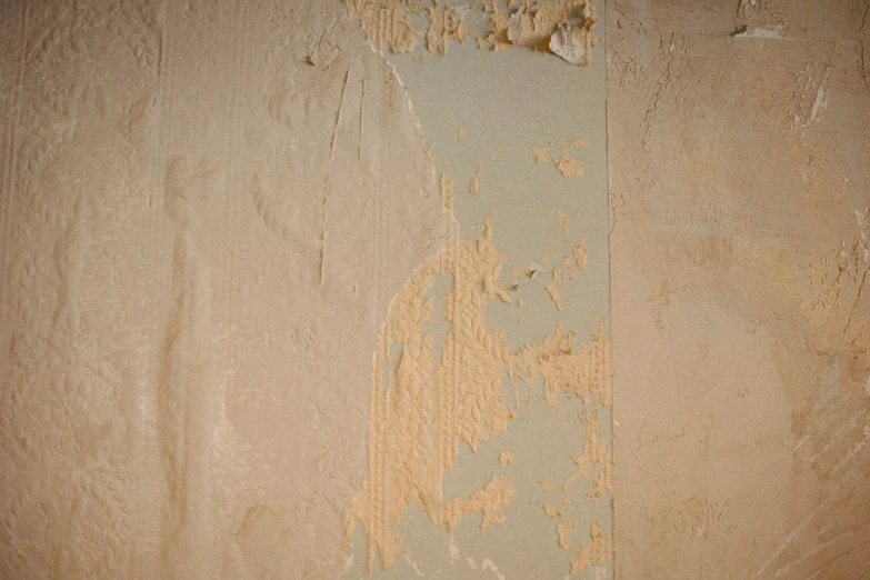 a wall with peeling paint and some stains on it