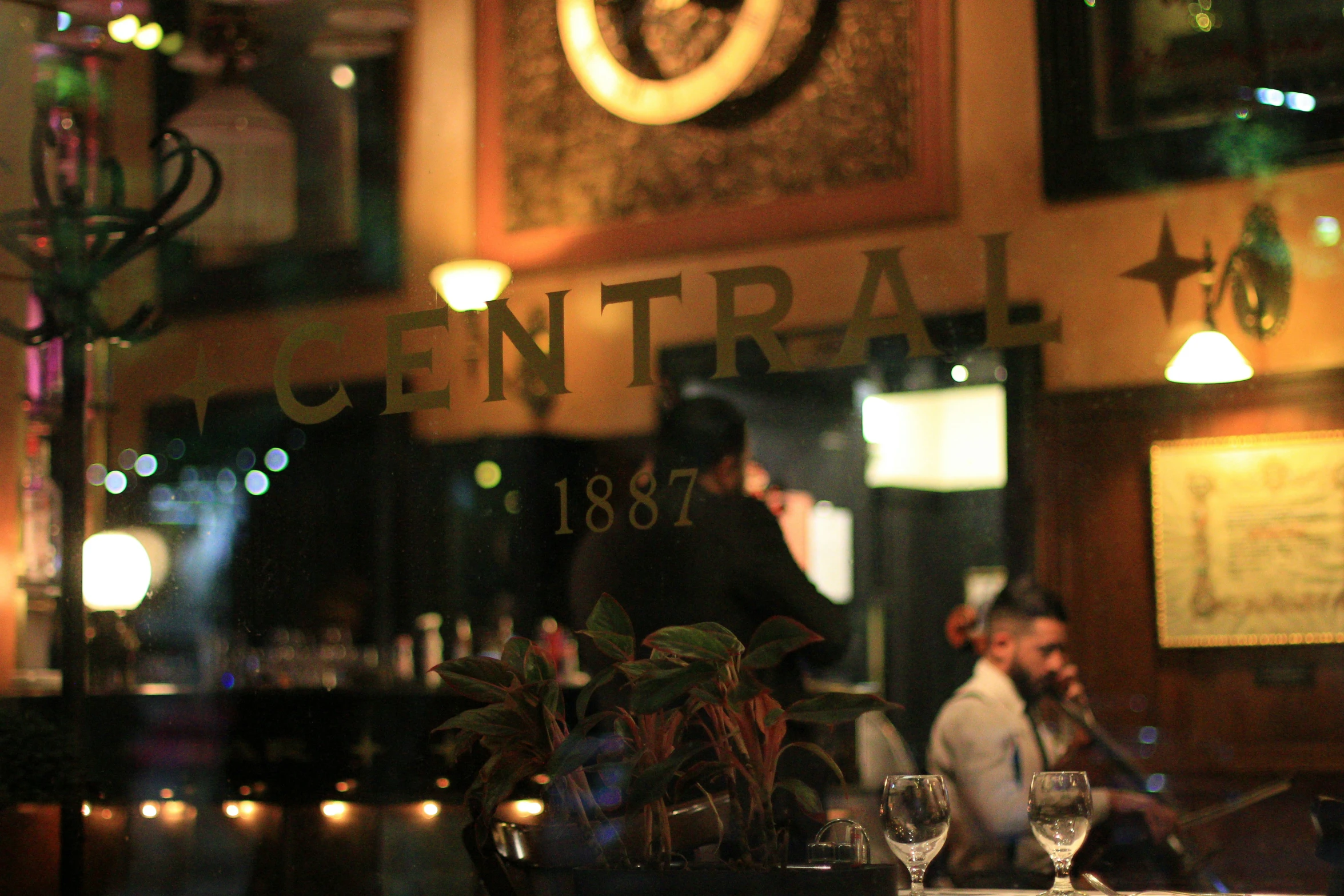 two people standing in front of a bar and the window to the restaurant