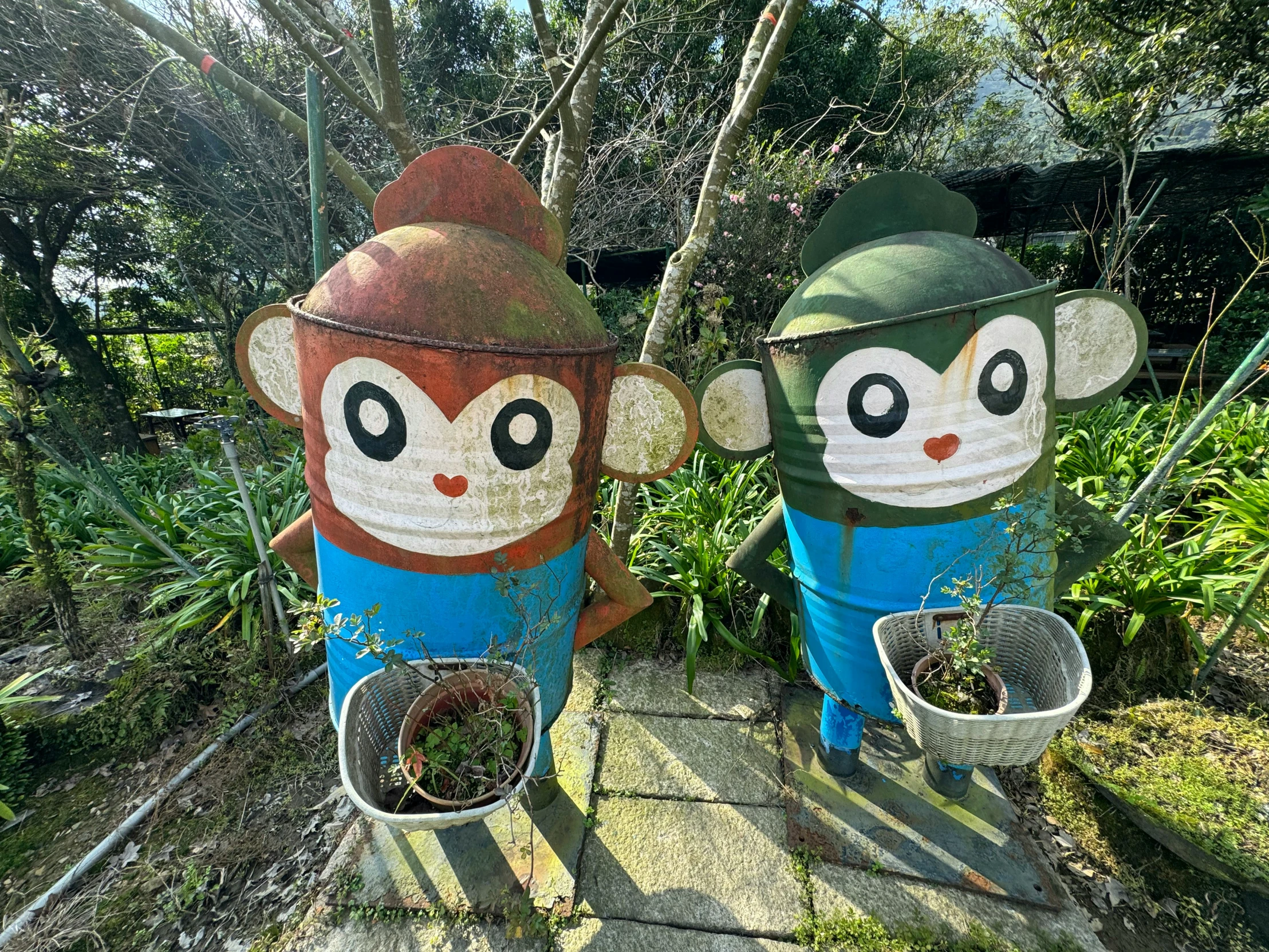 two decorative garden items made out of metal barrels