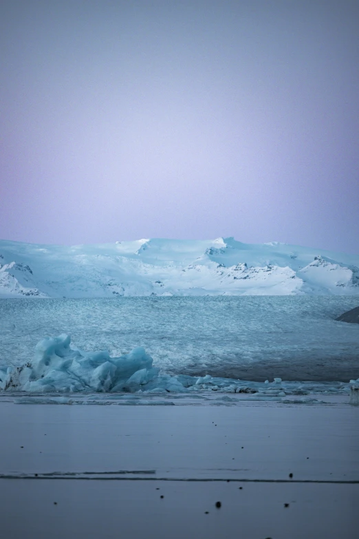 an iceberg stands alone in the snow