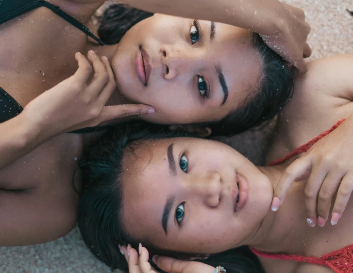 two woman in swimwear laying down together