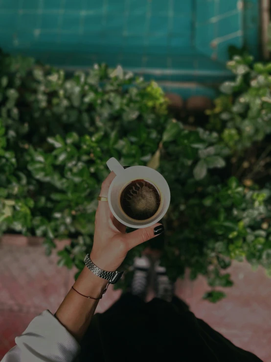 woman holding up a cup filled with coffee