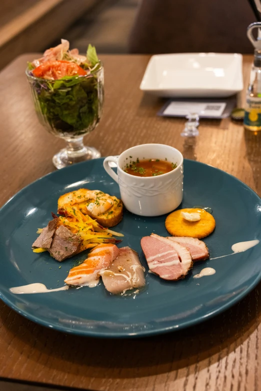 a plate with soup, vegetables and other items sitting on a table