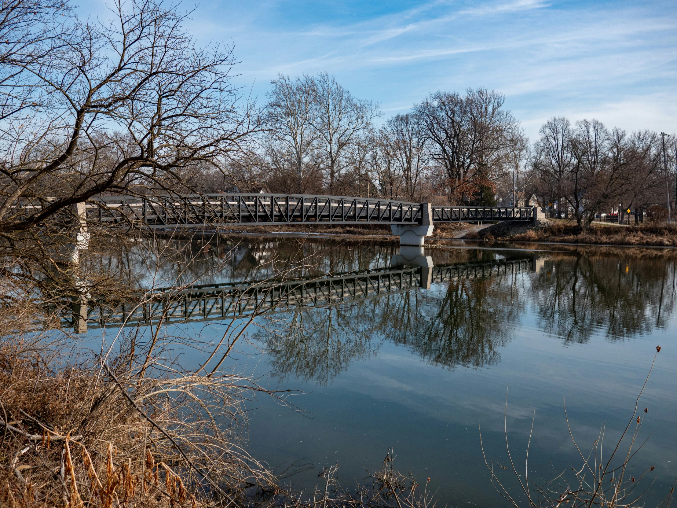 a bridge crosses over a lake on a bright sunny day