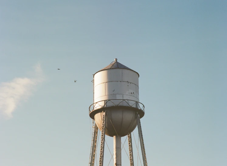 a water tower that is standing out against a blue sky