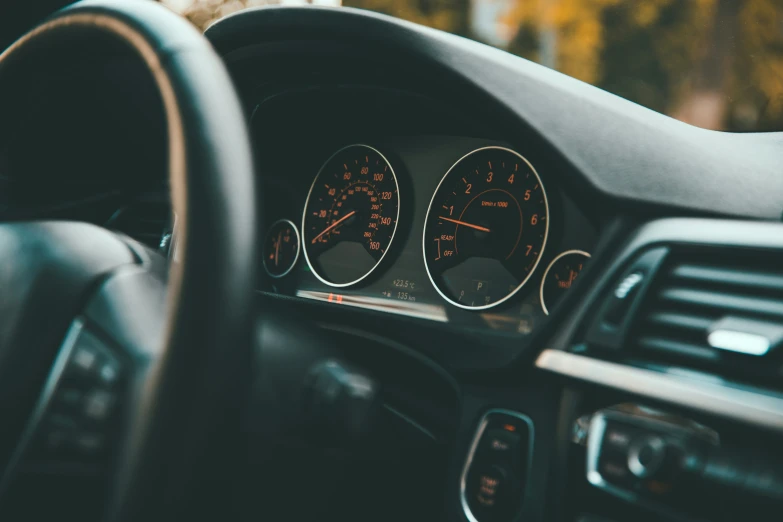 a car dashboard with an overexposed view of the gauges