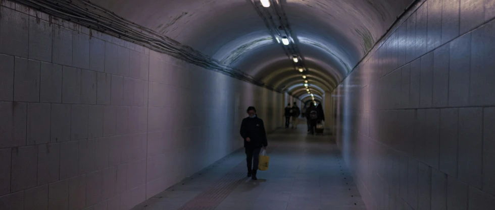 people are walking through an empty tunnel