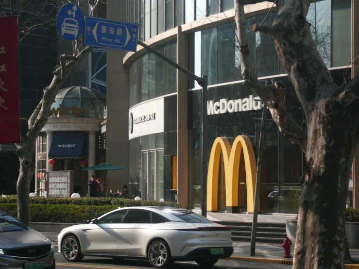 a car sitting on the side of a road near a mcdonalds