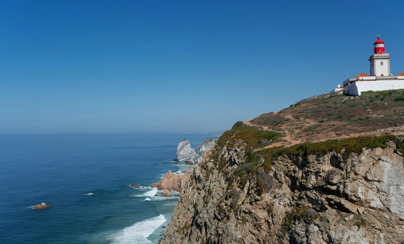 the lighthouse on top of the cliff above the ocean