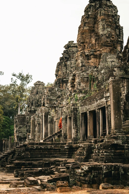 a man in red is standing near large ruins