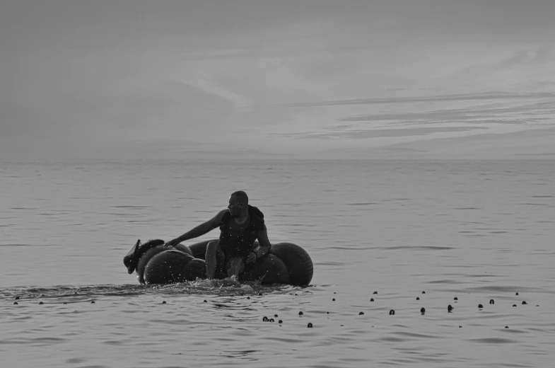 a woman sitting on the back of a body of water