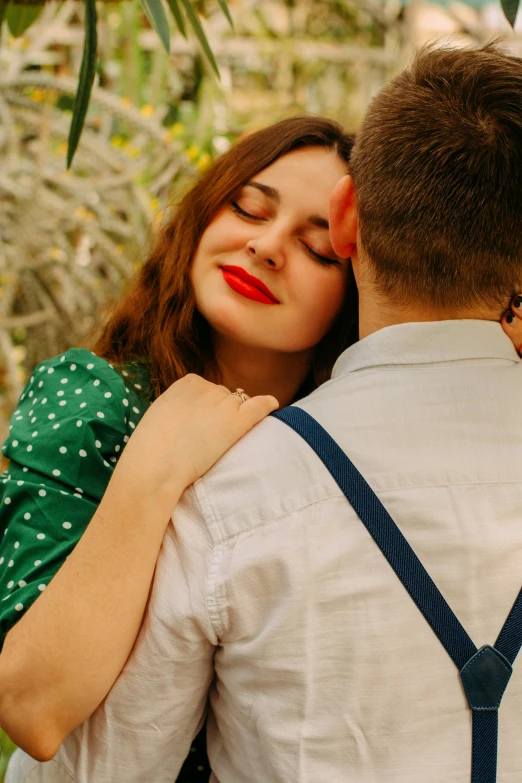 a couple emcing each other underneath a tree