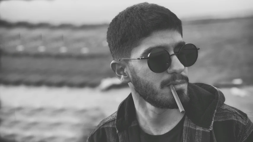 man with sunglasses smoking soing in his mouth